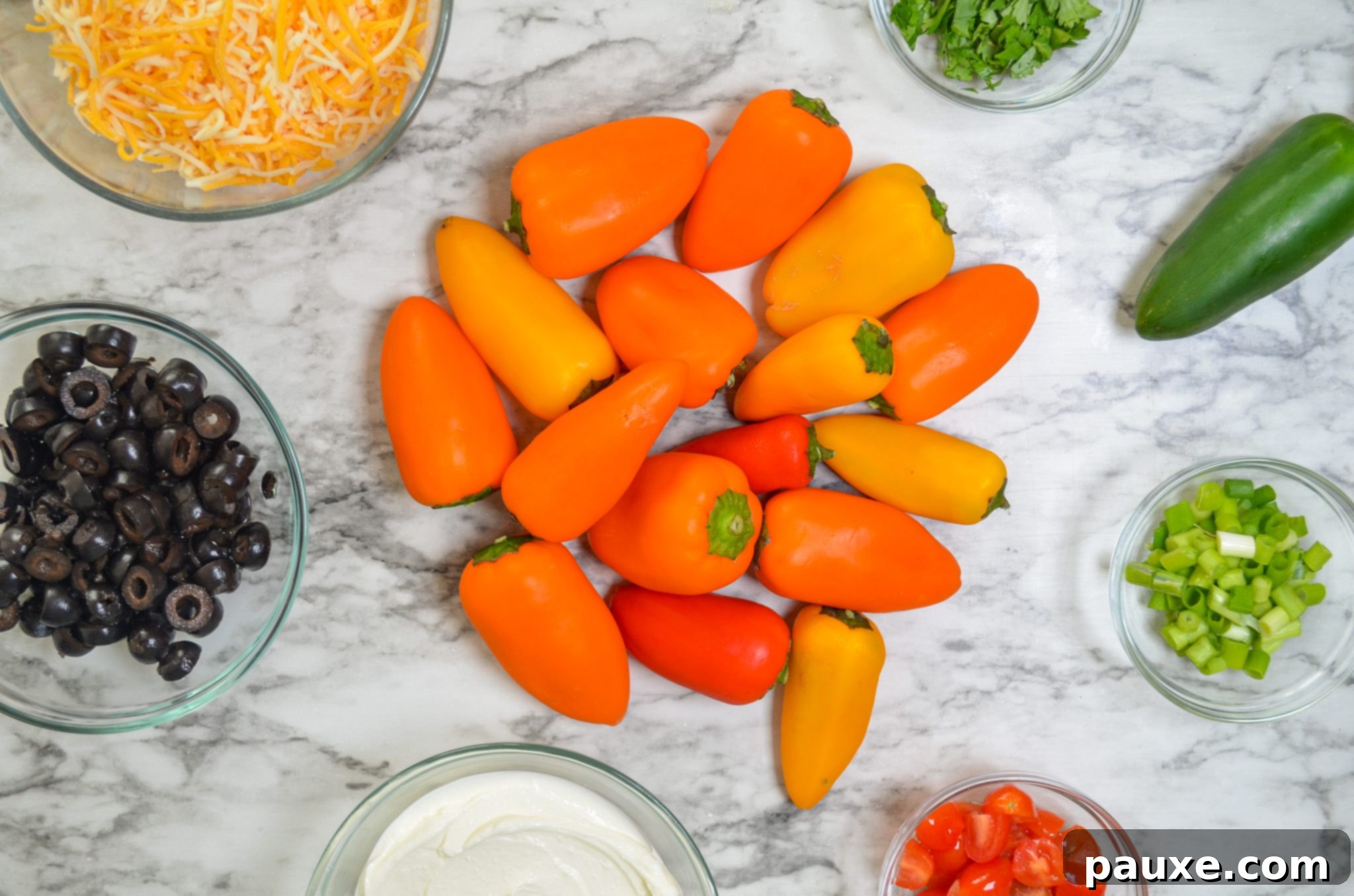 Loaded Air Fryer Mini Bell Pepper Nachos 4 An assortment of fresh ingredients laid out, including mini peppers, cheese, olives, and jalapenos.