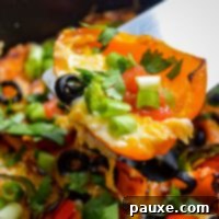 Loaded Air Fryer Mini Bell Pepper Nachos 8 A spatula lifting out a portion of pepper nachos.