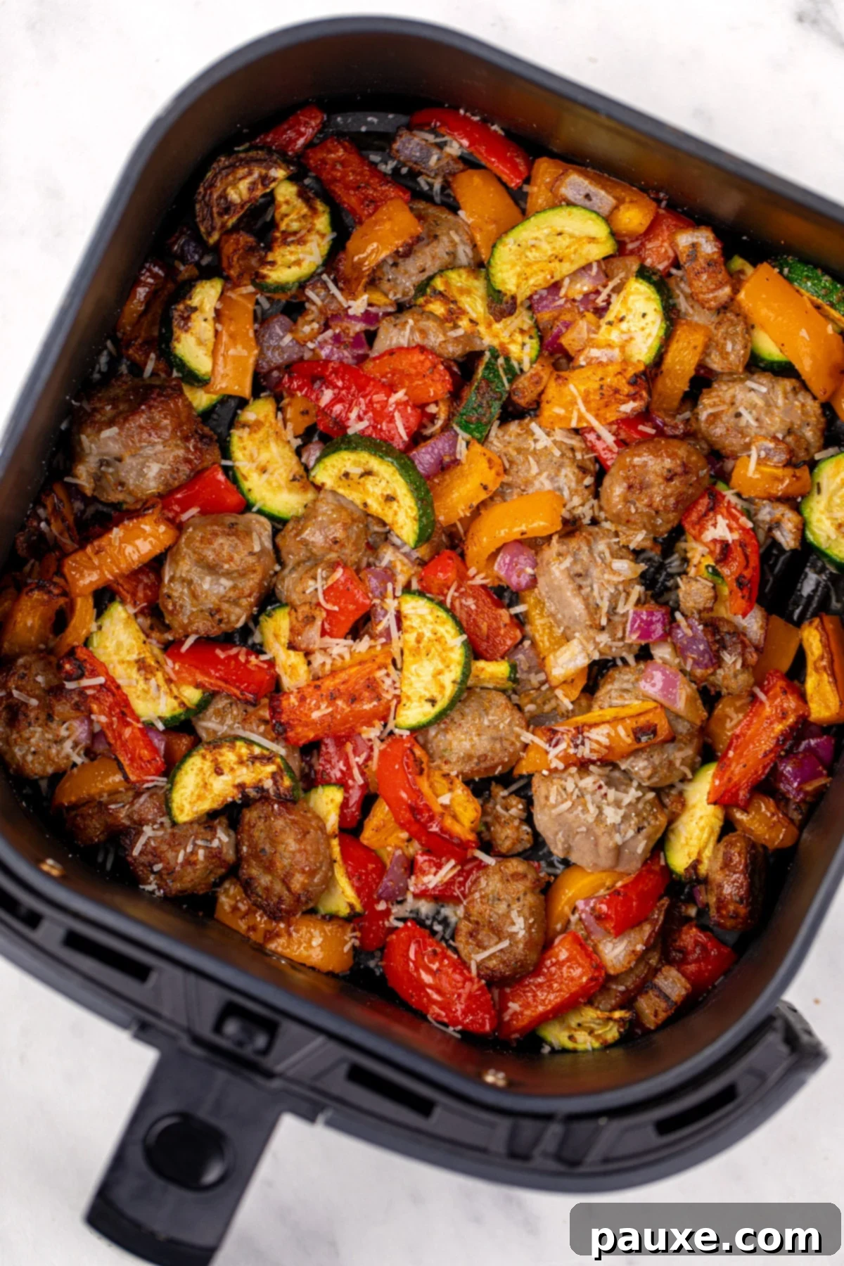 Air-Fried Chicken Sausage & Roasted Veggies 2 An air fryer basket filled with perfectly cooked chicken sausage and a colorful array of vegetables.