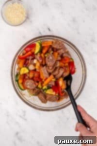 Air-Fried Chicken Sausage & Roasted Veggies 12 Stirring vegetables and sliced sausage together in a bowl.