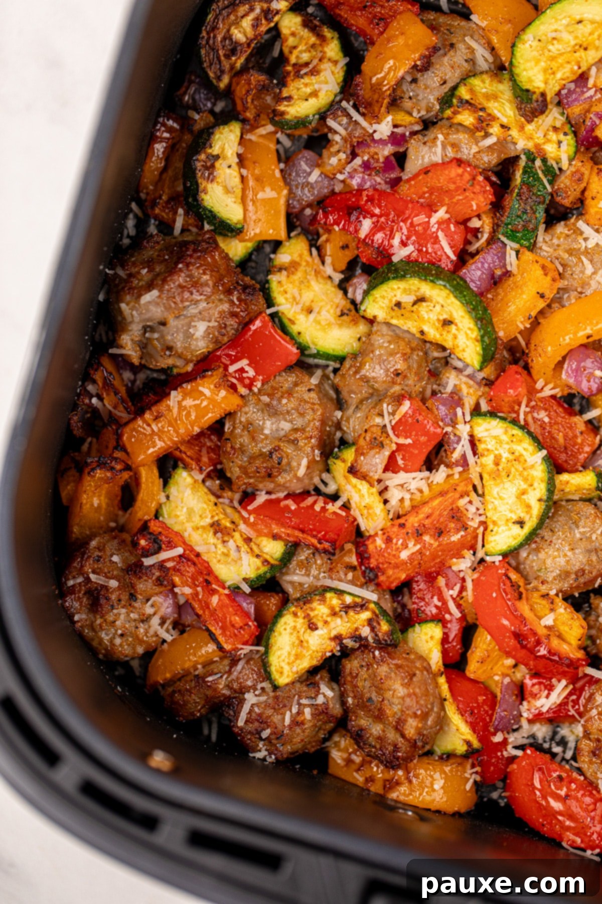 Air-Fried Chicken Sausage & Roasted Veggies 8 A close-up of tender, cooked vegetables including zucchini, red pepper, and red onion, showing their crispy edges from the air fryer.