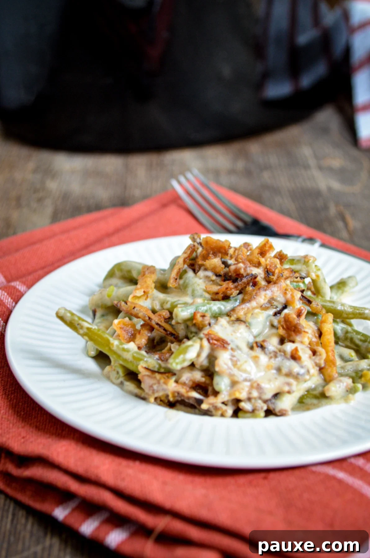 Crockpot Green Bean Comfort 2 A serving of green bean casserole, with a slow cooker in the background.