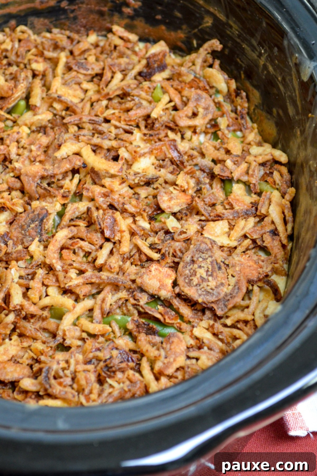 Crockpot Green Bean Comfort 7 A slow cooker full of green bean casserole, topped with french fried onions.