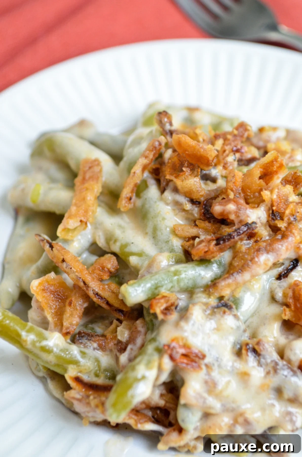 Crockpot Green Bean Comfort 8 A serving of green bean casserole on a white plate, topped with french fried onions.