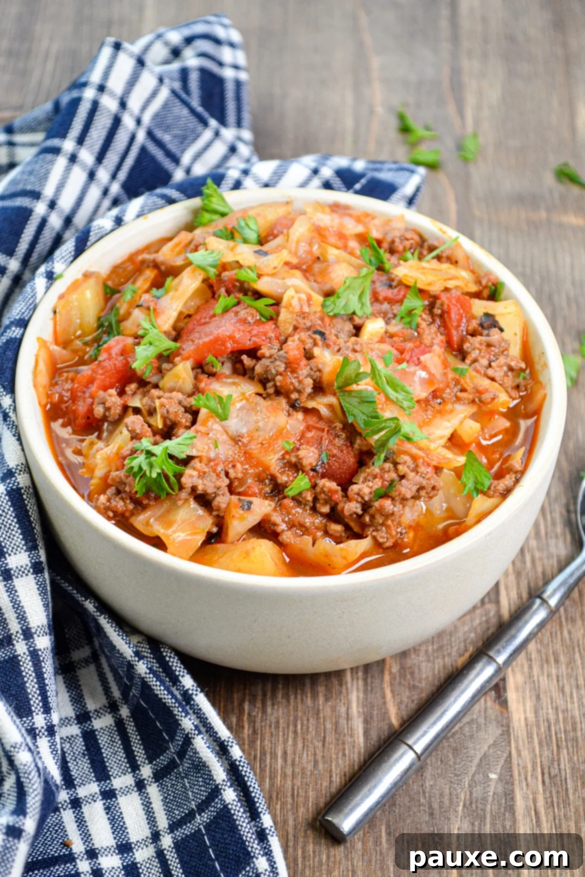 Instant Pot Lazy Cabbage Roll Dinner 2 A bowl of cabbage and ground beef hash, filled with tomatoes and topped with parsley.