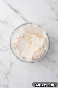 Baked Pepperoni Pizza Dip 12 A bowl of cream cheese mixed with other ingredients, including cheese.