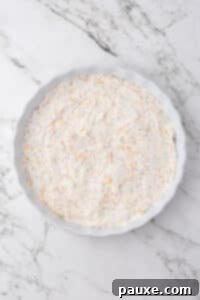 Baked Pepperoni Pizza Dip 13 Cream cheese layered in the bottom of a round baking dish, dotted with cheddar cheese.