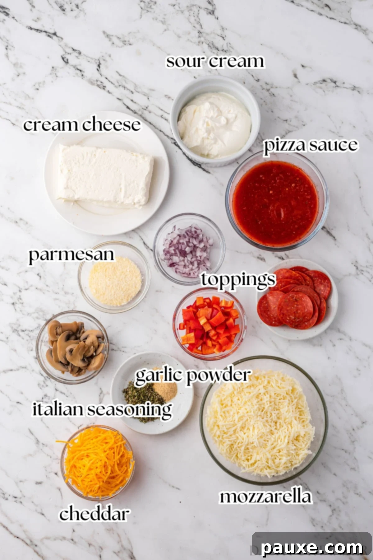 Baked Pepperoni Pizza Dip 3 The ingredients needed to make pizza dip, including softened cream cheese, sour cream, pizza sauce, various cheeses, and Italian seasonings, arranged neatly on a surface.