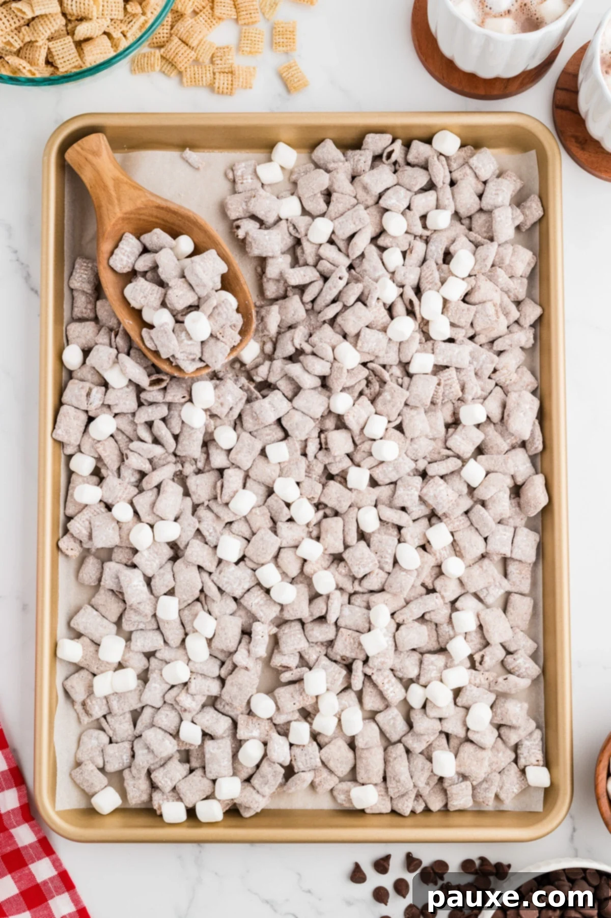 A baking sheet filled with Puppy Chow snack mix, with some mini marshmallows tossed in.