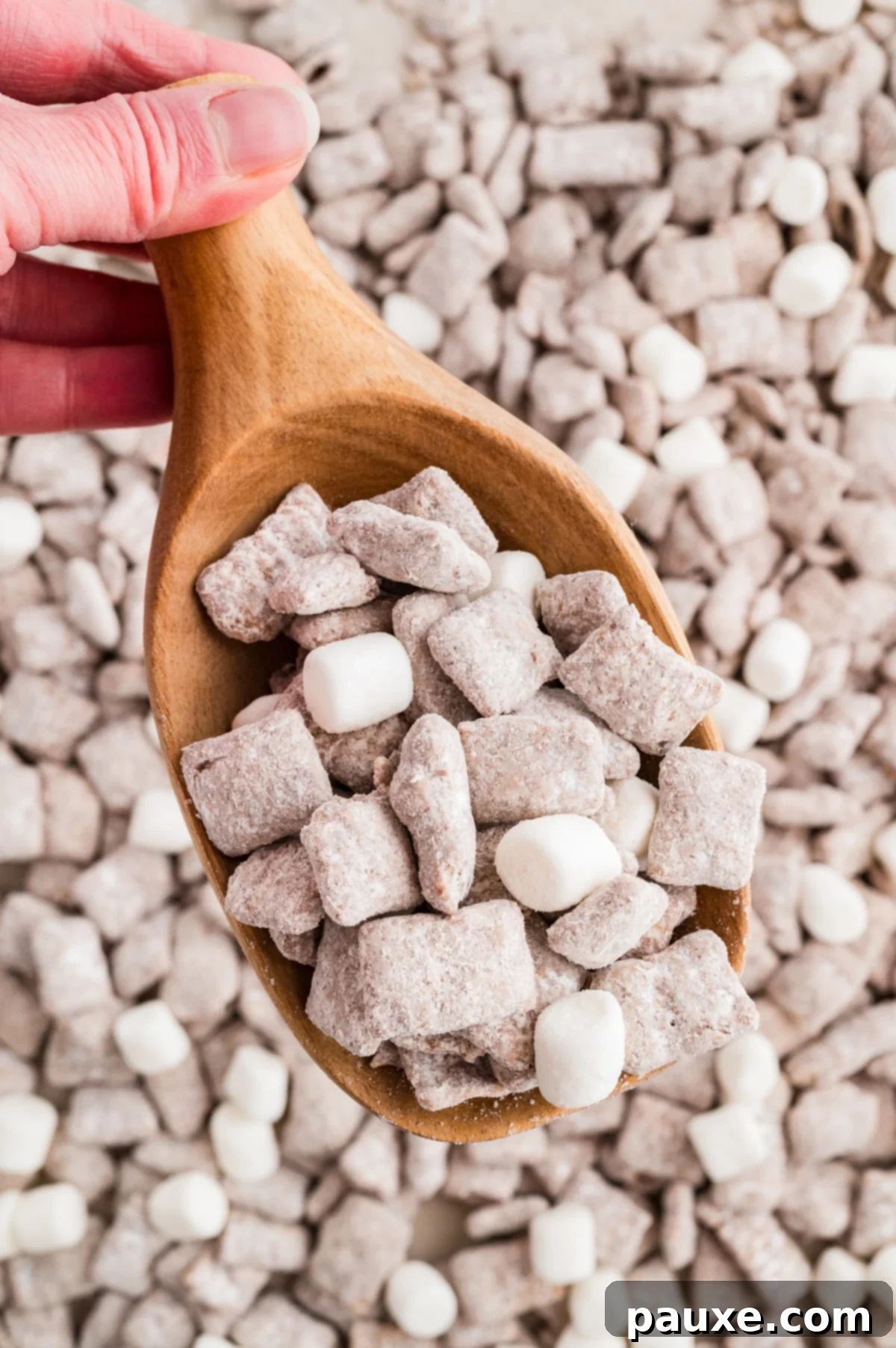 Scooping muddy buddies from a larger amount.