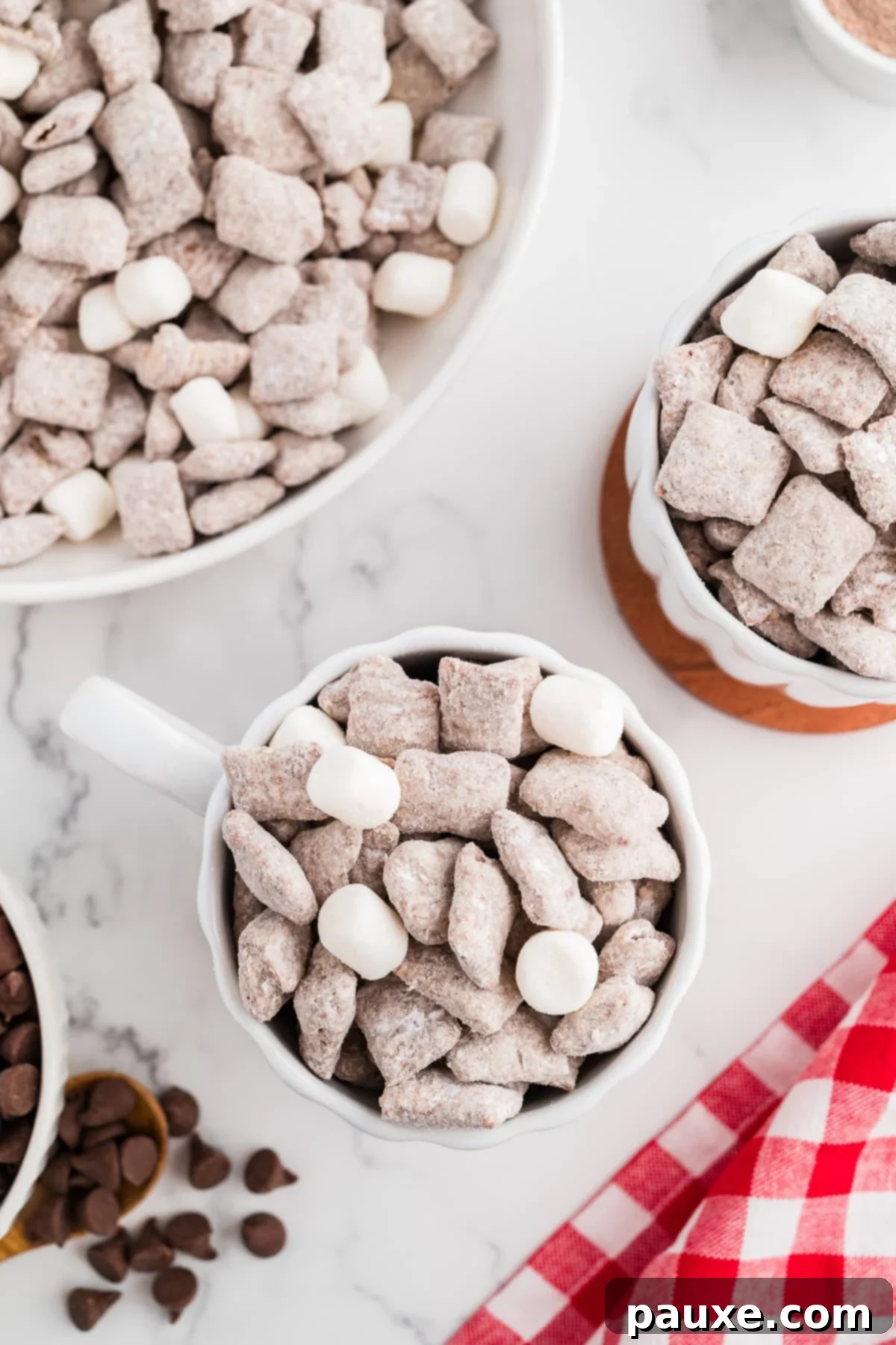 A mug full of muddy buddies, topped with a few marshmallows.