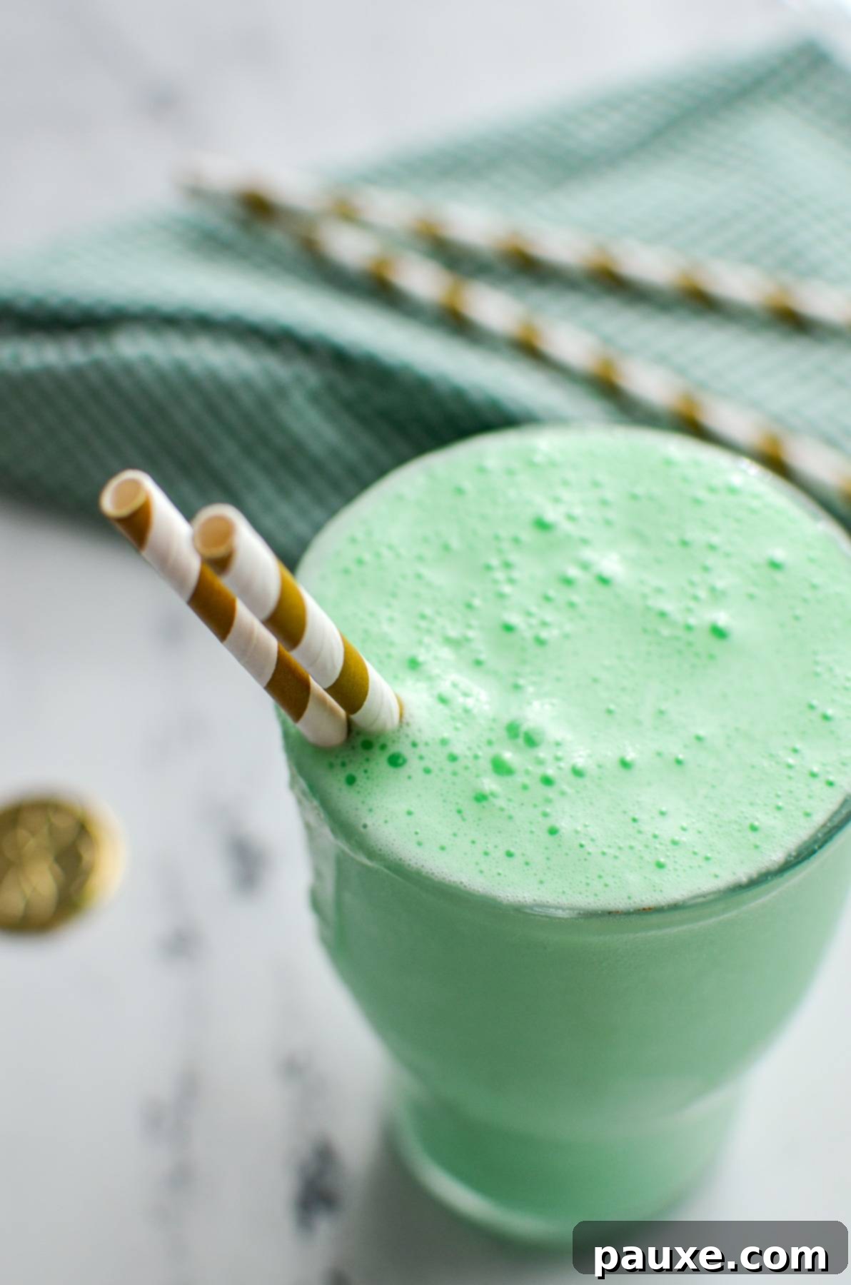 Whip Up Your Own McDonald's Shamrock Shake 2 A large glass holding a green milkshake, with two straws sticking out of the side.