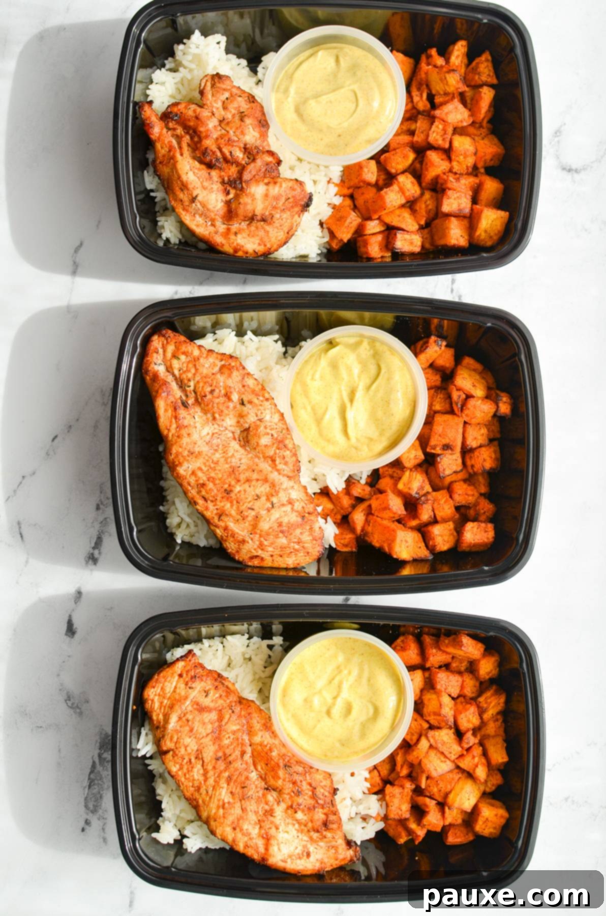 Crispy Air-Fried Blackened Chicken 7 Meal prep containers with chicken, sweet potatoes, curry mayo, and rice.
