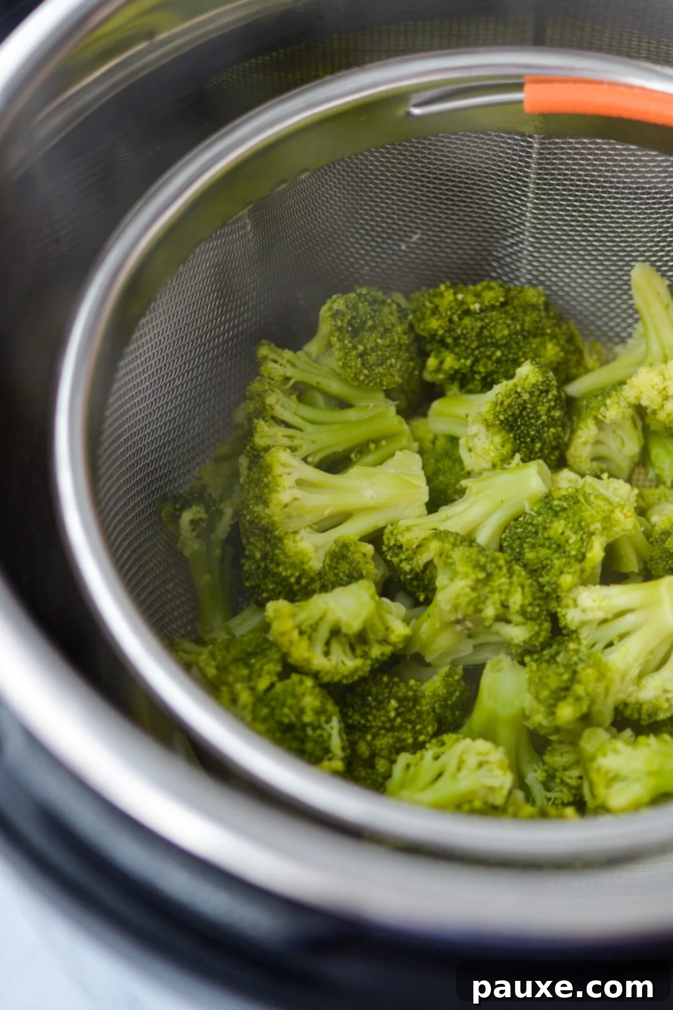 Perfect Instant Pot Frozen Broccoli 9 Cooked broccoli inside a steamer basket in the Instant Pot, showing its vibrant green color.
