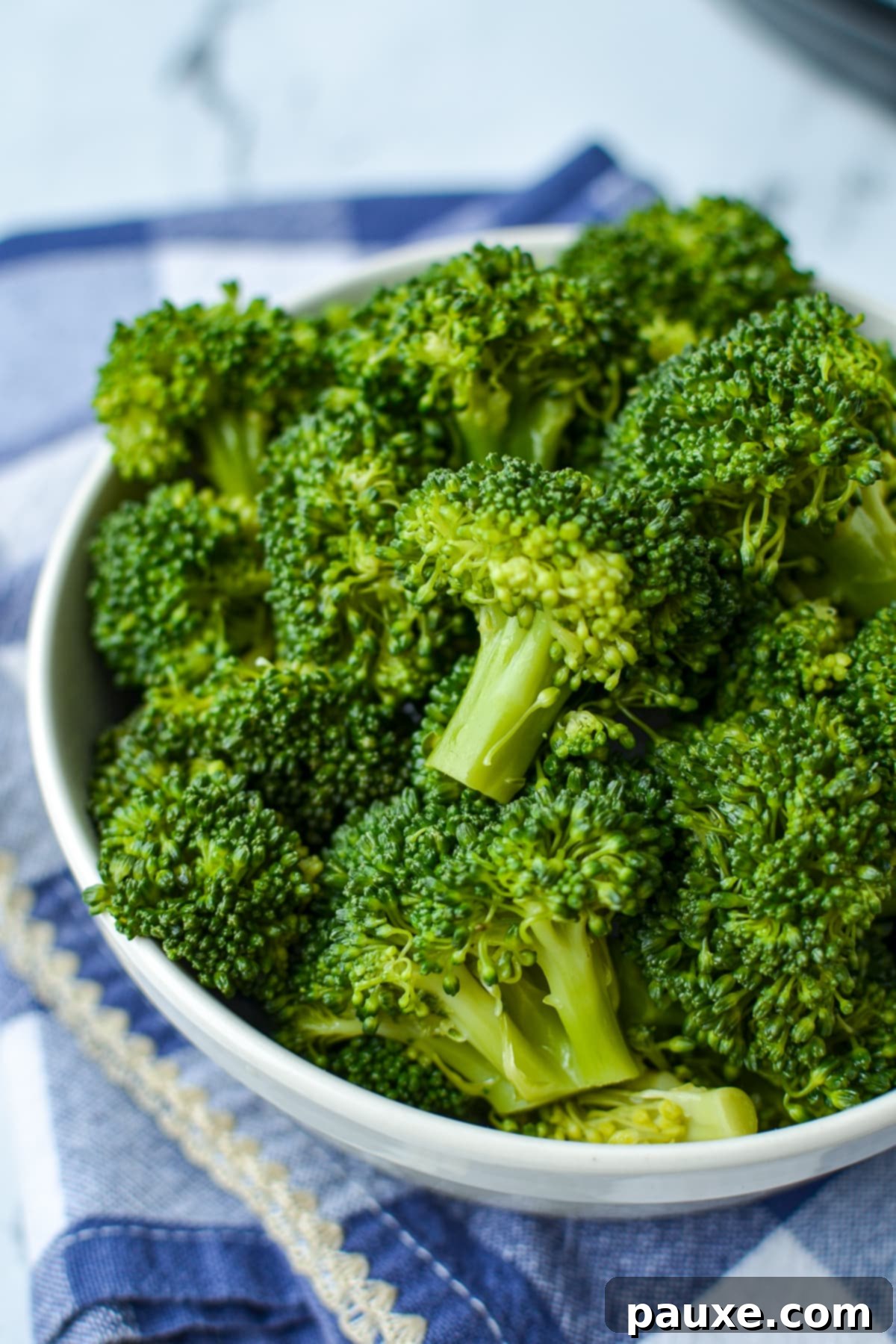 Effortless Instant Pot Broccoli 6 A close-up of a bowl filled with perfectly tender cooked broccoli florets, ready to be seasoned and served.