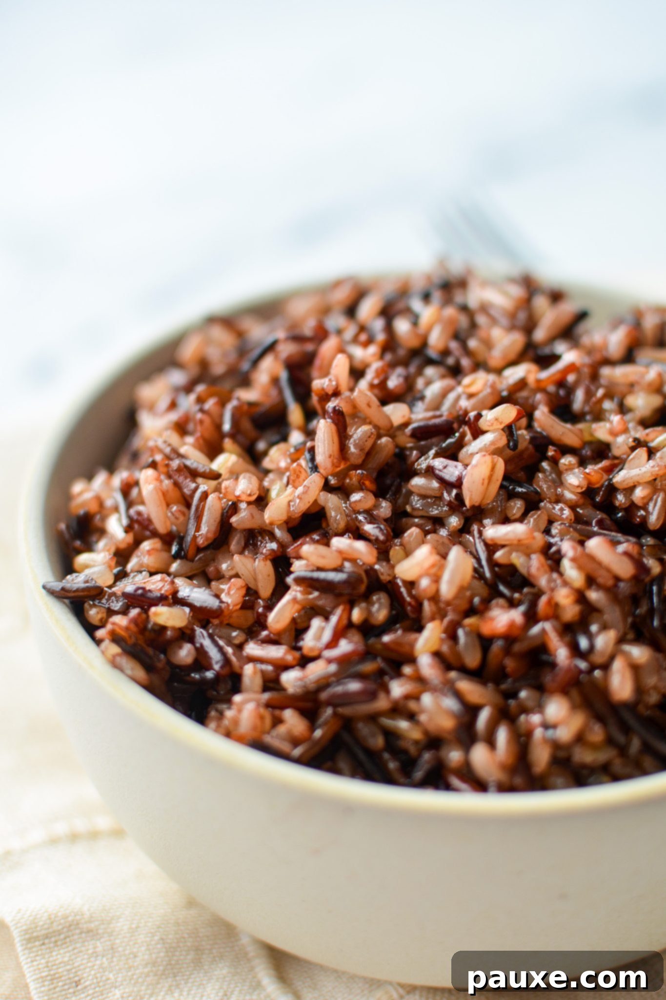 Perfect Instant Pot Wild Rice Medley 2 A bowl of wild rice blend artfully arranged on a soft cloth napkin.