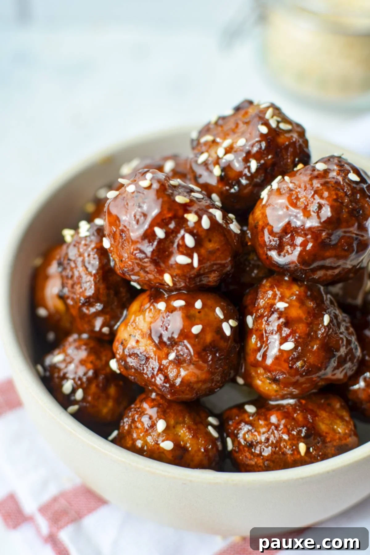 Perfect Air Fryer Frozen Meatballs 8 A delicious bowl of glazed meatballs, beautifully garnished with sesame seeds and herbs, highlighting their perfect texture.