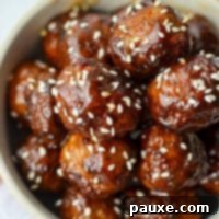 Perfect Air Fryer Frozen Meatballs 9 A stack of glazed meatballs, garnished with sesame seeds, presented beautifully as a finished dish.