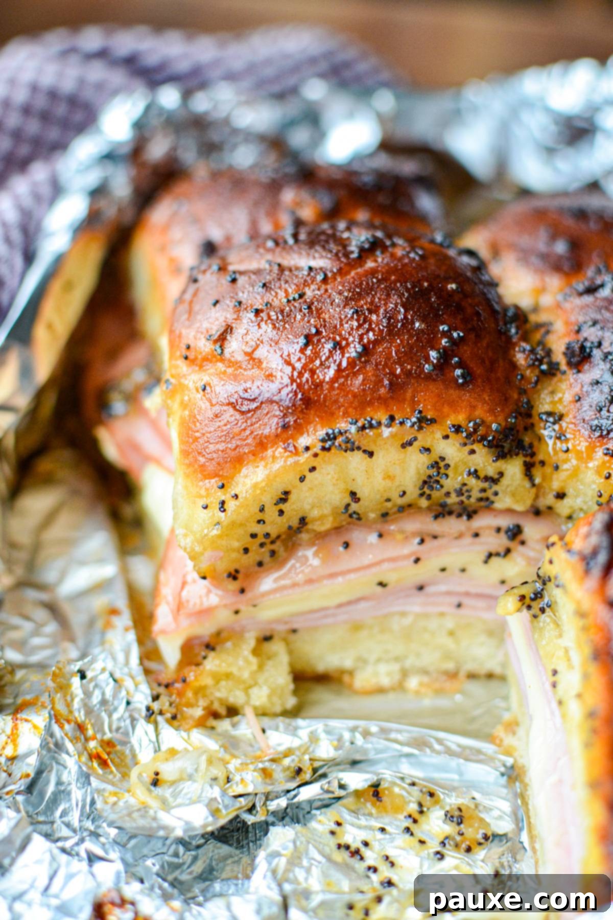 Golden Air Fryer Ham and Cheese Sliders 6 A flat of ham and cheese sliders, lined with aluminum foil.