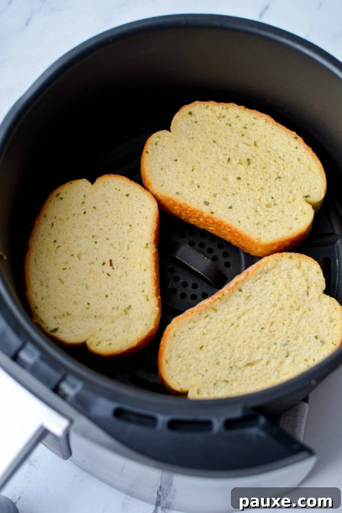 Crispy Air Fryer Texas Garlic Toast 4 3 slices of garlic toast neatly arranged in the basket of an air fryer, ready for cooking.