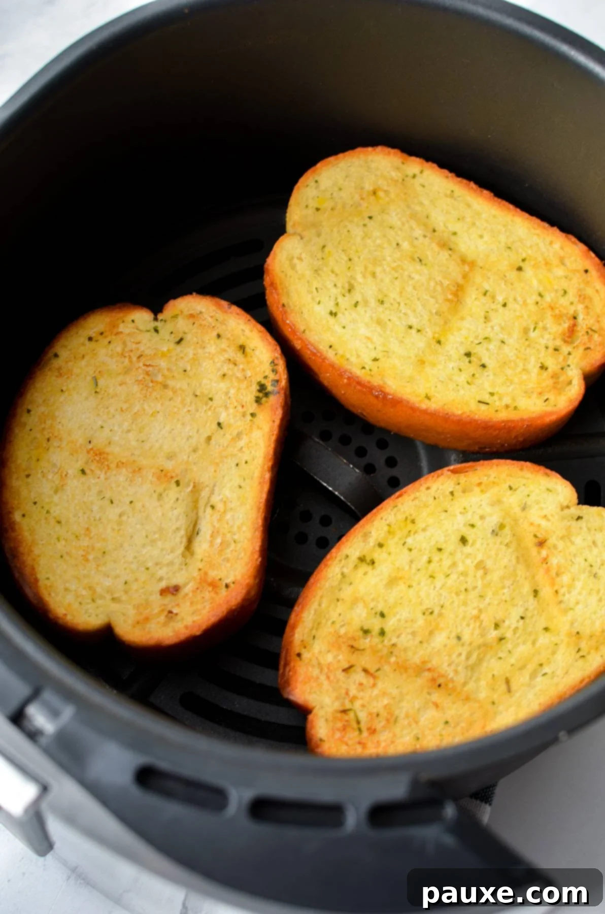 Crispy Air Fryer Texas Garlic Toast 7 Browned and toasted garlic bread slices glistening in the basket of an air fryer, perfectly cooked.