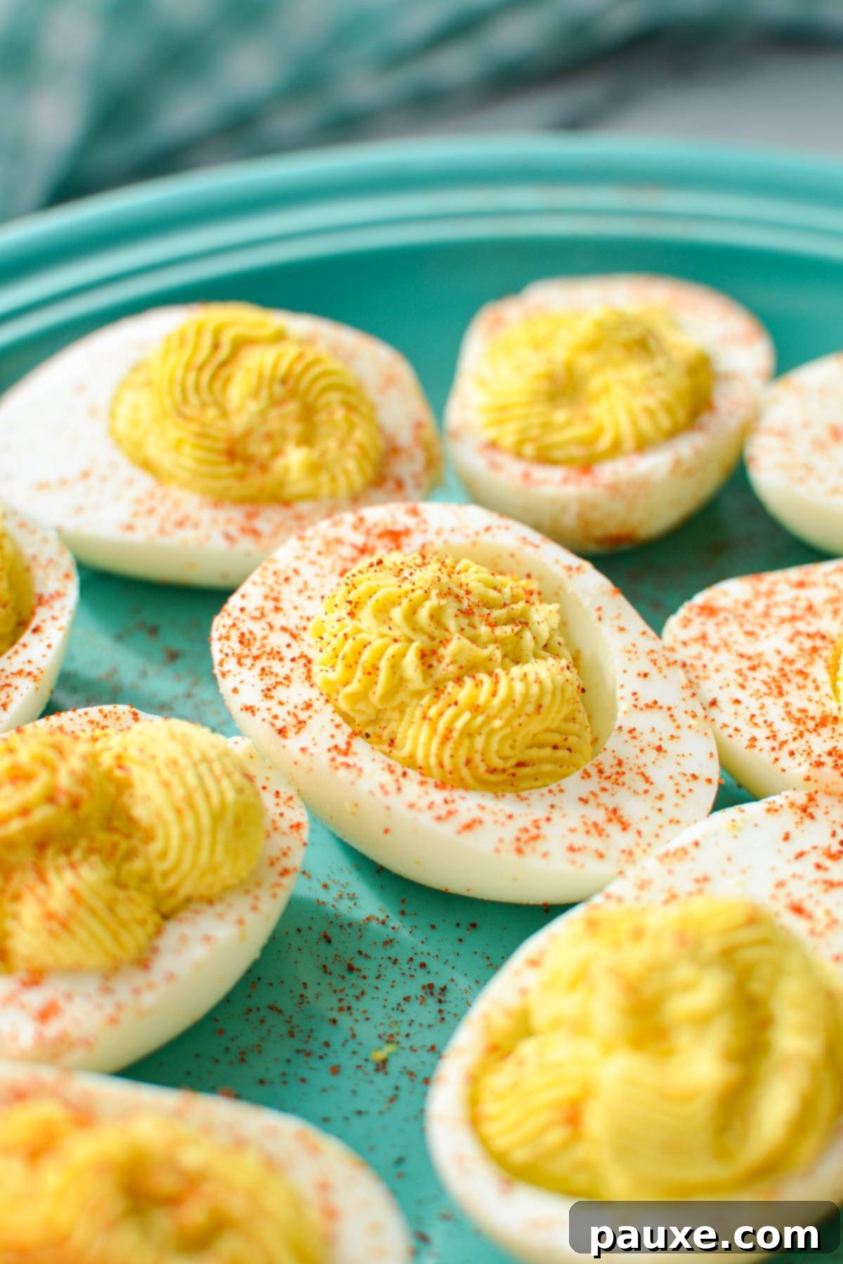 Effortless Instant Pot Deviled Eggs 2 A plate of deviled eggs, sprinkled with paprika.