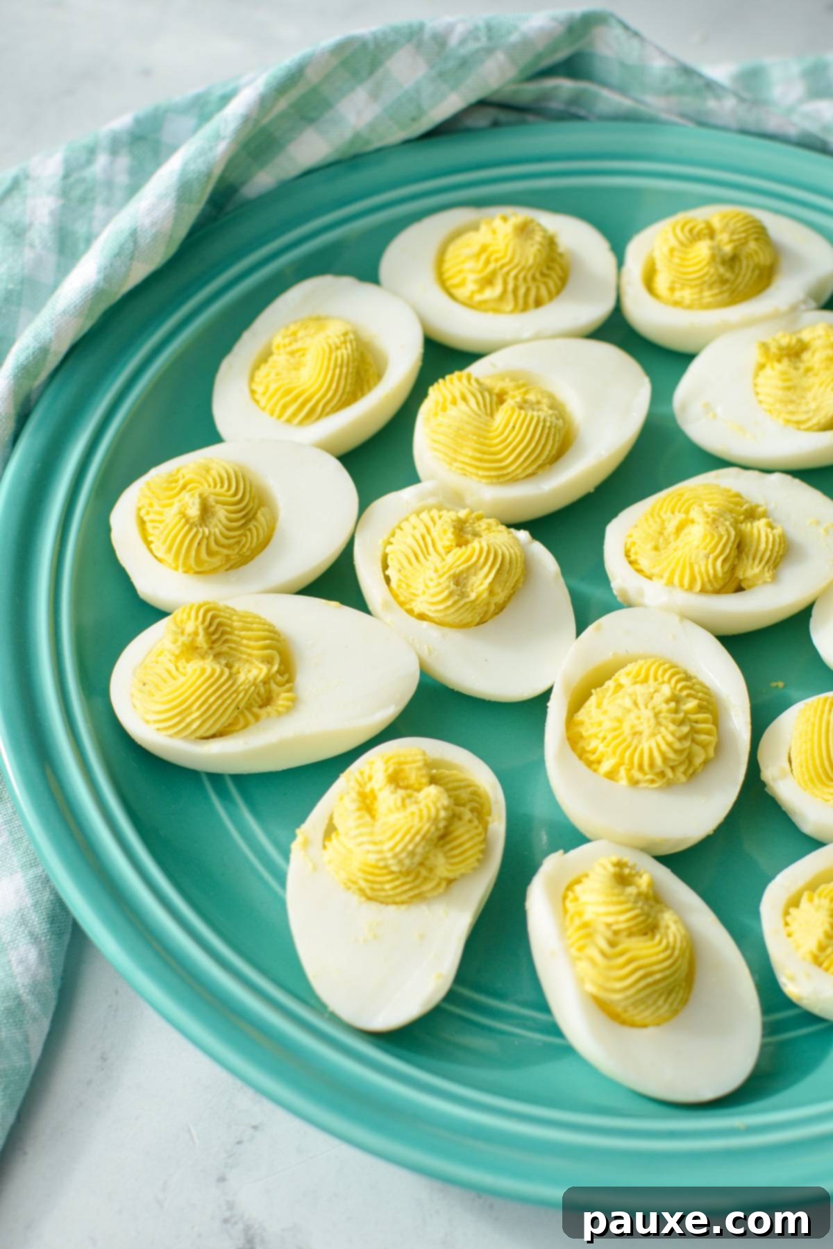 Effortless Instant Pot Deviled Eggs 8 An aqua colored plate of deviled eggs.