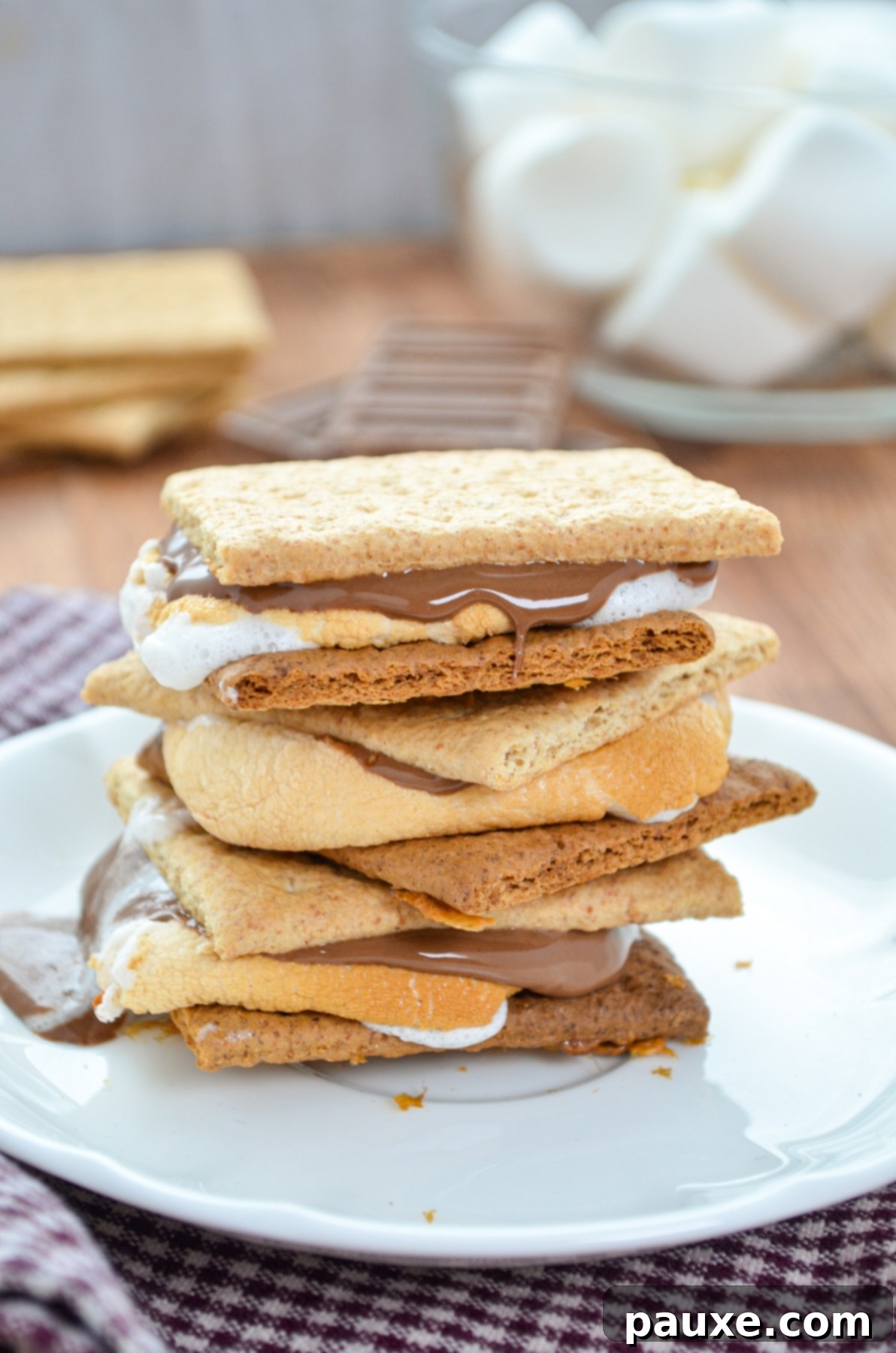 Air Fryer S'mores Magic 2 A stack of three smores on a small white plate.