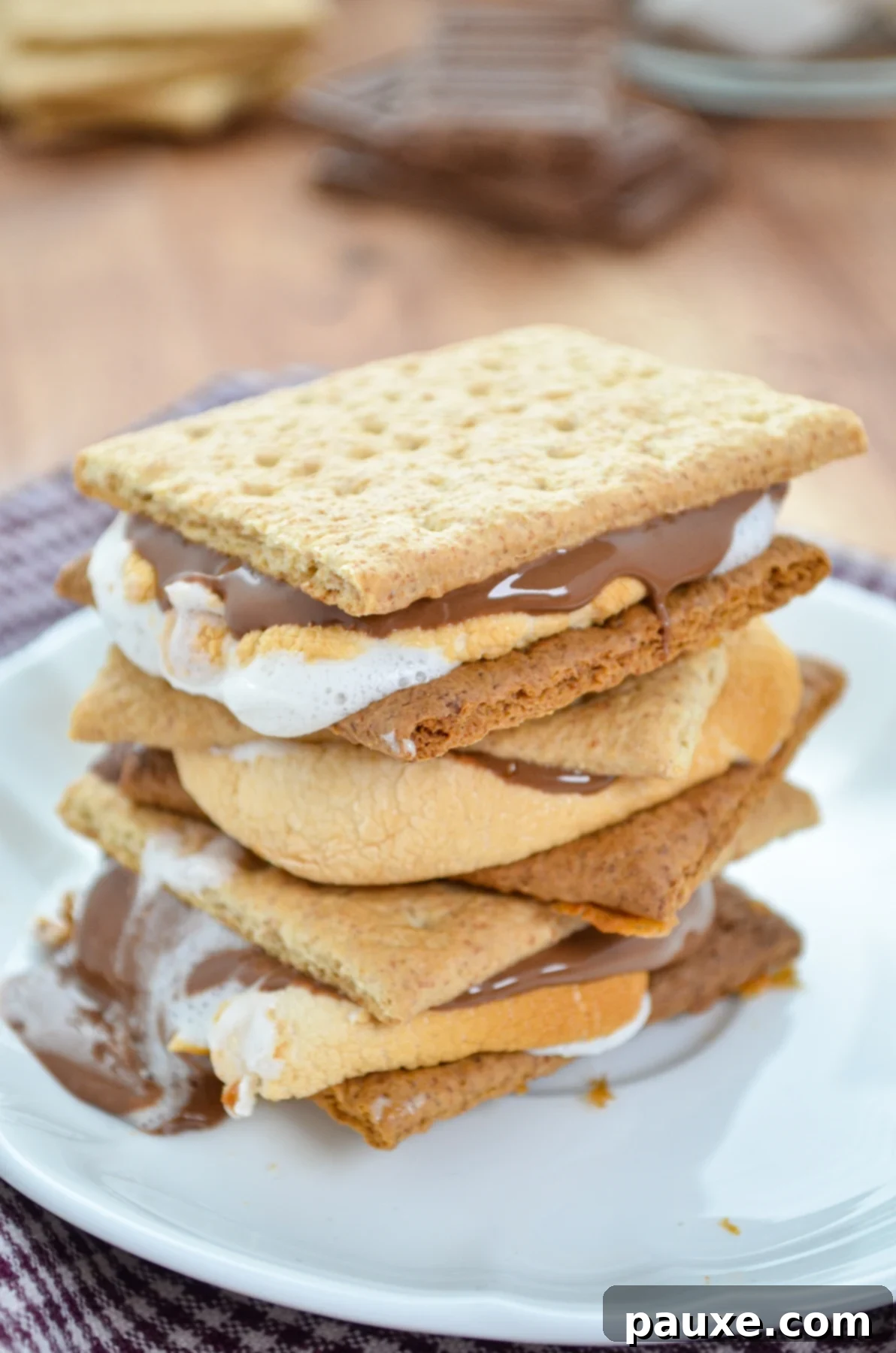 Air Fryer S'mores Magic 9 A stack of three s'mores on a white plate.
