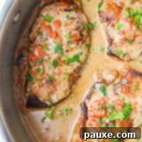 Velvety Roasted Red Pepper Chicken 10 A skillet filled with chicken breasts coated in a red pepper cream sauce, and garnished with parsley.
