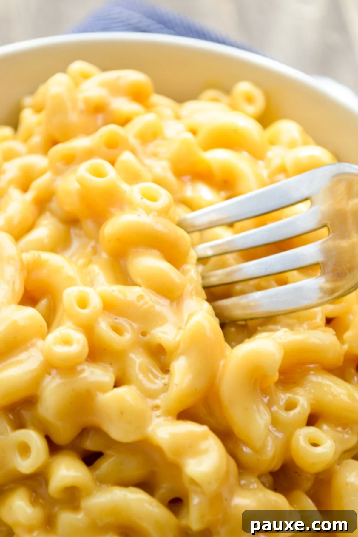 5-Ingredient Instant Pot Velveeta Mac and Cheese 2 A fork sunken into a big bowl of Instant Pot Mac and Cheese.