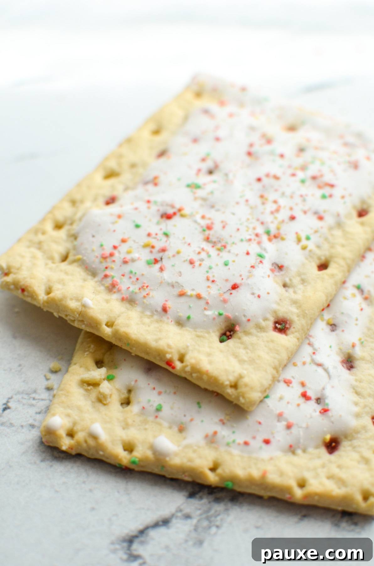 Air Fryer Toaster Pastries 3 Two pop tarts laying on a marble counter.