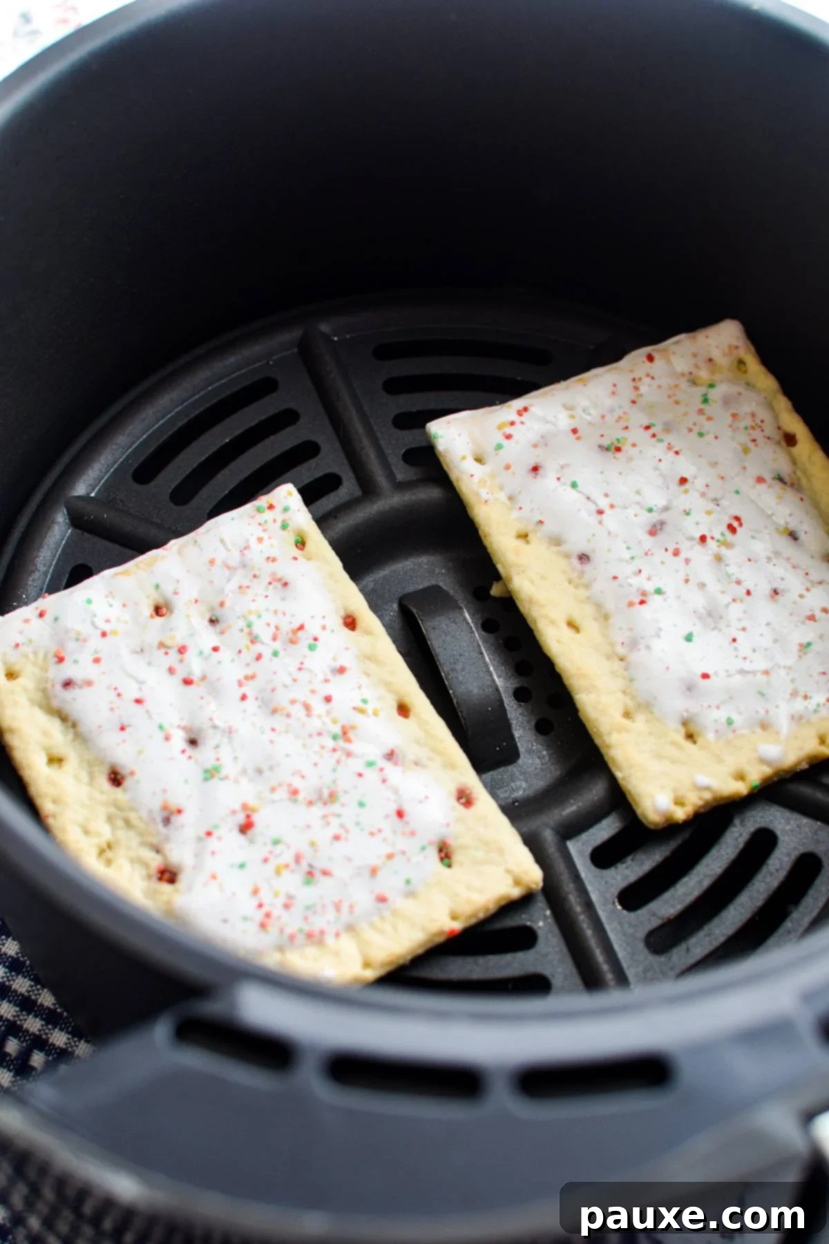 Air Fryer Toaster Pastries 4 Adding pop tarts to the basket of an air fryer.