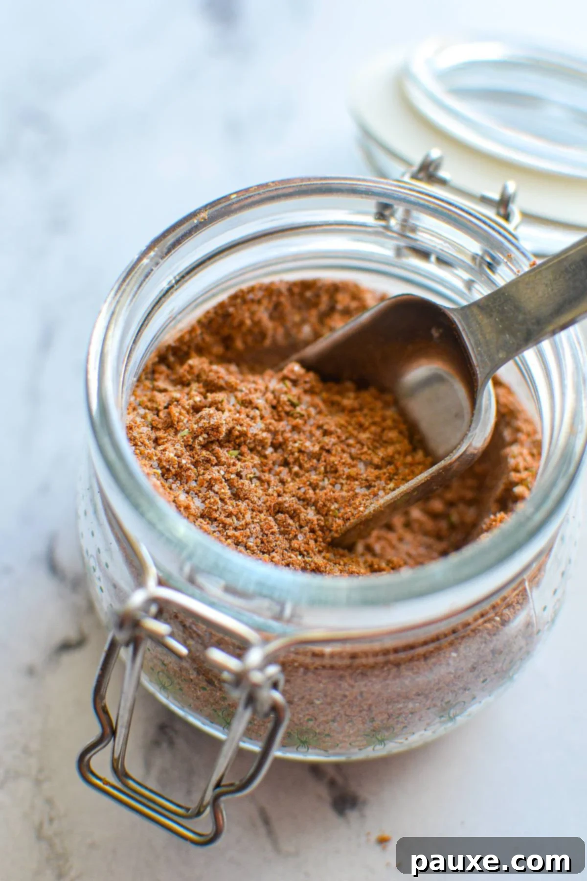 Taco Night Magic Spice 2 A small jar of taco seasoning with a measuring spoon inside.