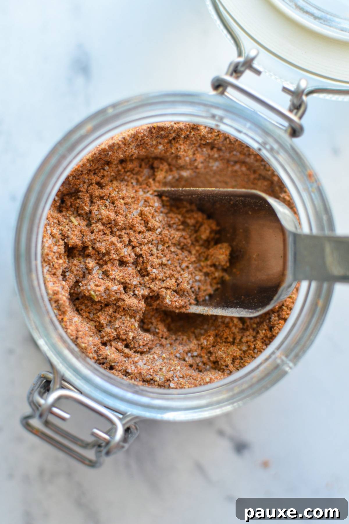 Taco Night Magic Spice 5 An overhead shot of a jar of taco seasoning with a spoon inside.