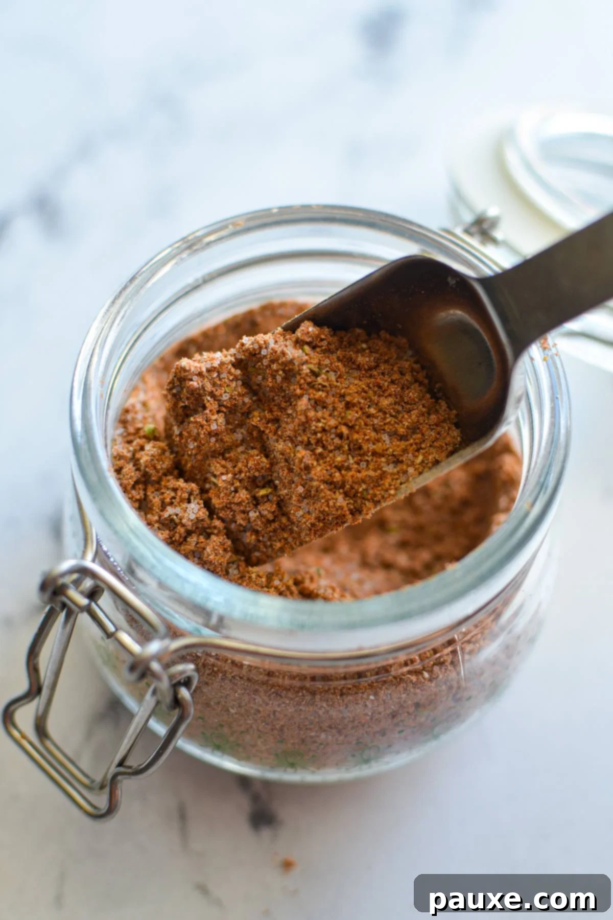 Taco Night Magic Spice 6 A small jar of taco seasoning with a spoon inside.