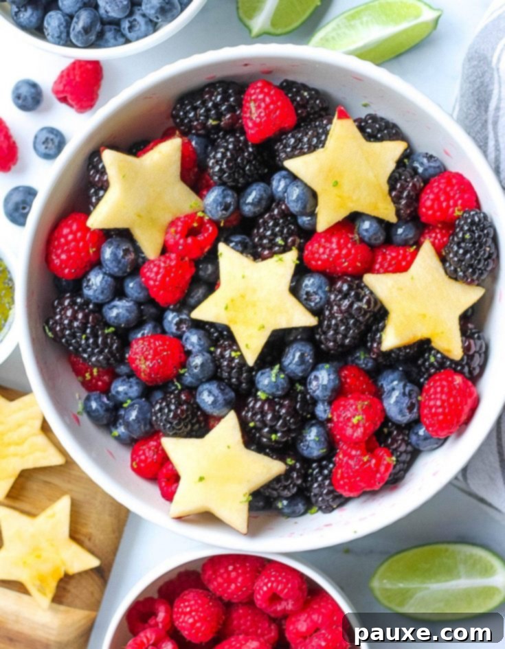 A vibrant berry fruit salad adorned with melon and apple stars, showcasing patriotic colors perfect for summer.