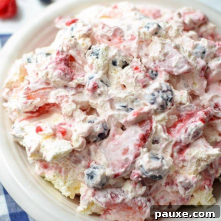 A creamy red, white, and blue cheesecake salad, abundantly loaded with fresh berries for a patriotic treat.