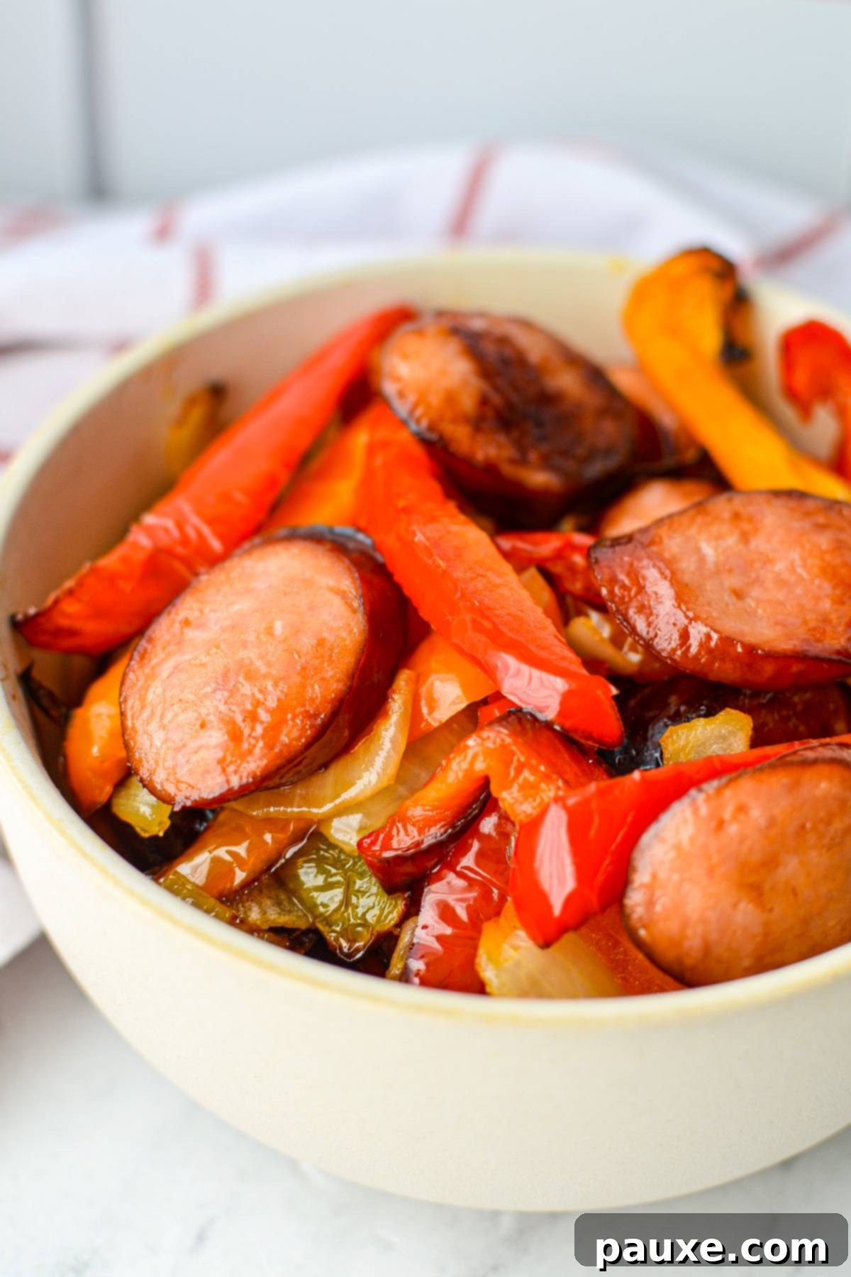 Crispy Air Fryer Sausage and Peppers 6 A bowl of cooked sausage slices and sliced peppers.