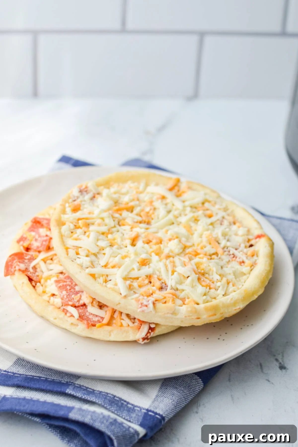 Crispy Air Fryer Frozen Mini Pizzas 3 Two frozen mini pizzas arranged on a plate, ready for the air fryer.