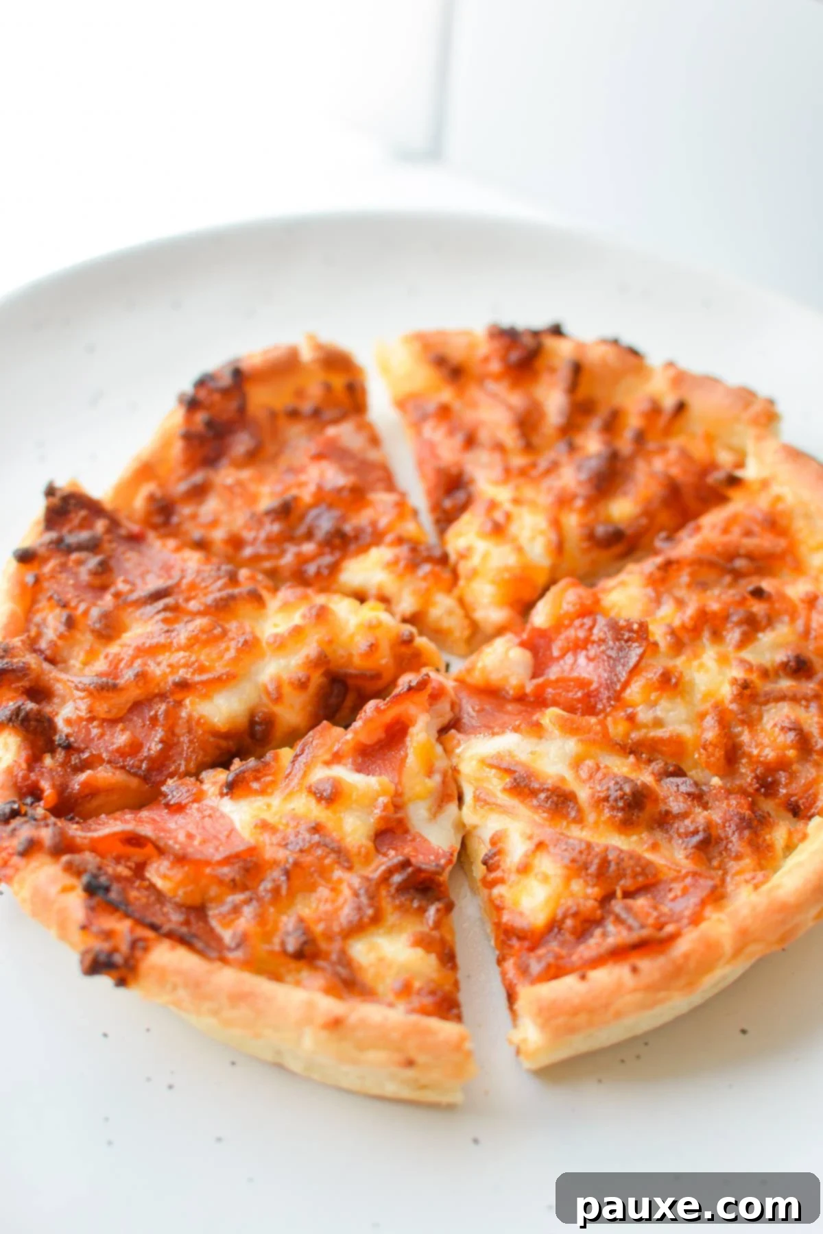 Crispy Air Fryer Frozen Mini Pizzas 6 A cooked mini pizza, sliced into 6 pieces, on a wooden cutting board.