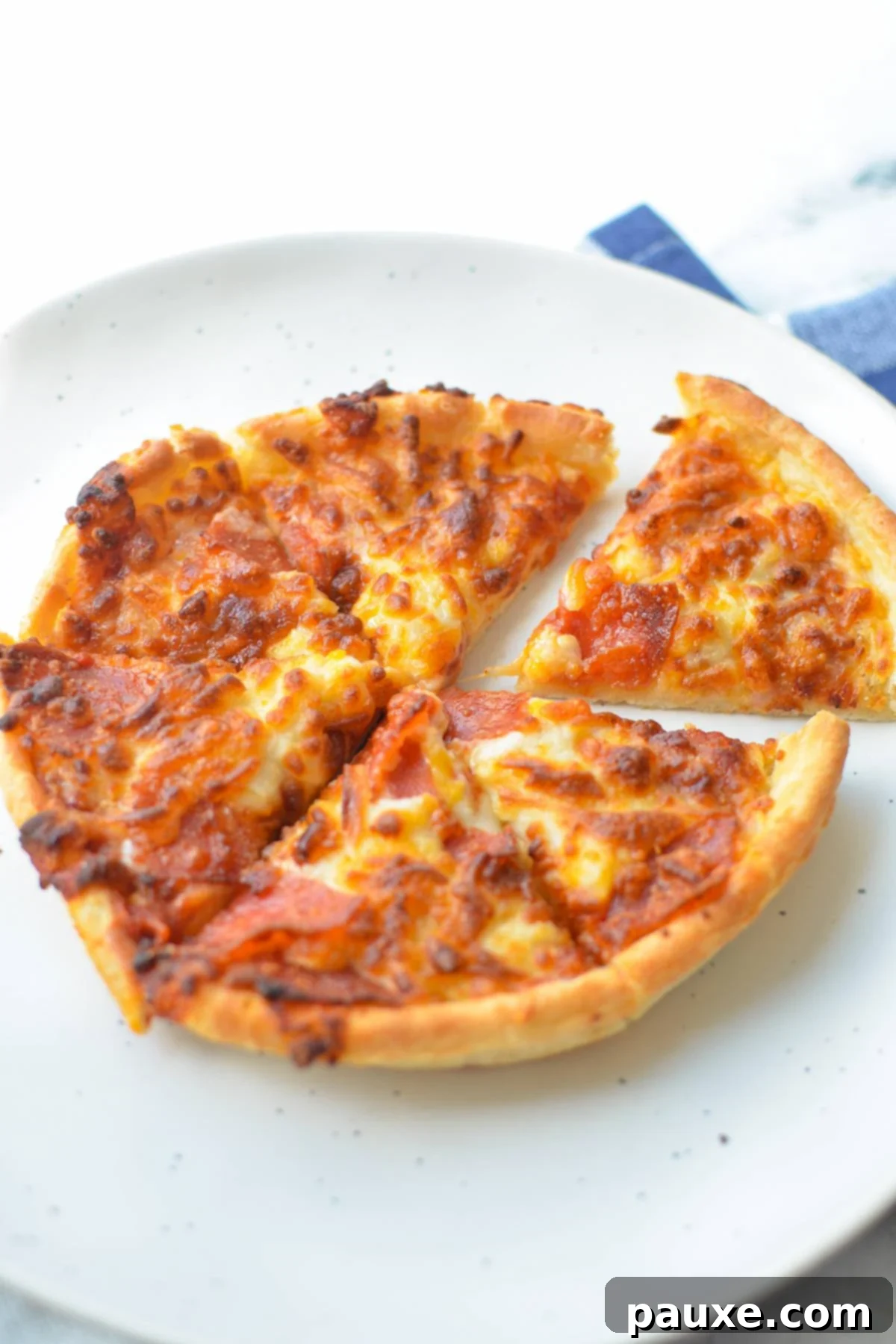 Crispy Air Fryer Frozen Mini Pizzas 7 A mini pizza on a plate, cut into 6 slices, garnished for serving.