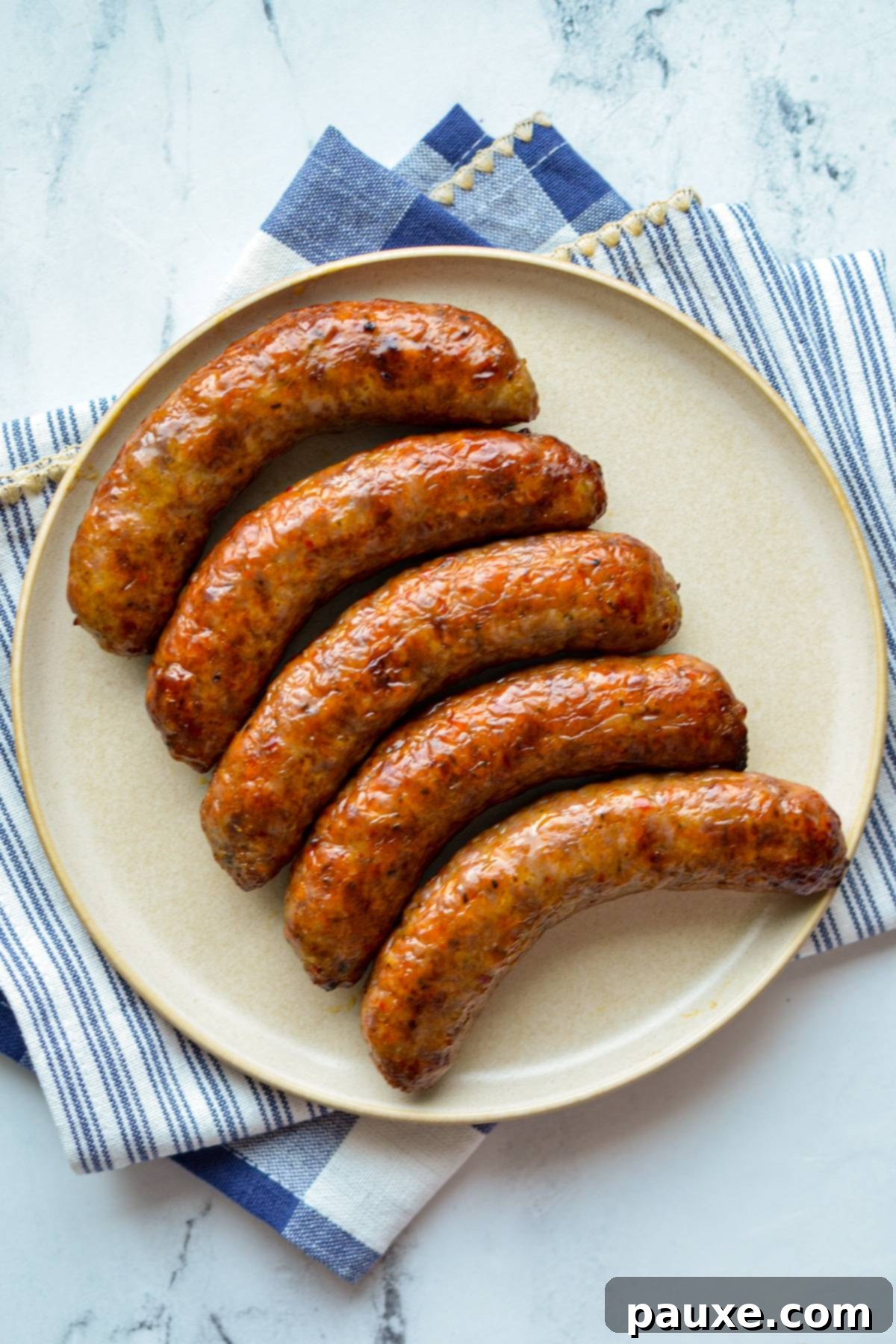 Crispy Air Fryer Italian Sausages 5 An overhead shot of a plate with beautifully cooked, browned Italian sausages.