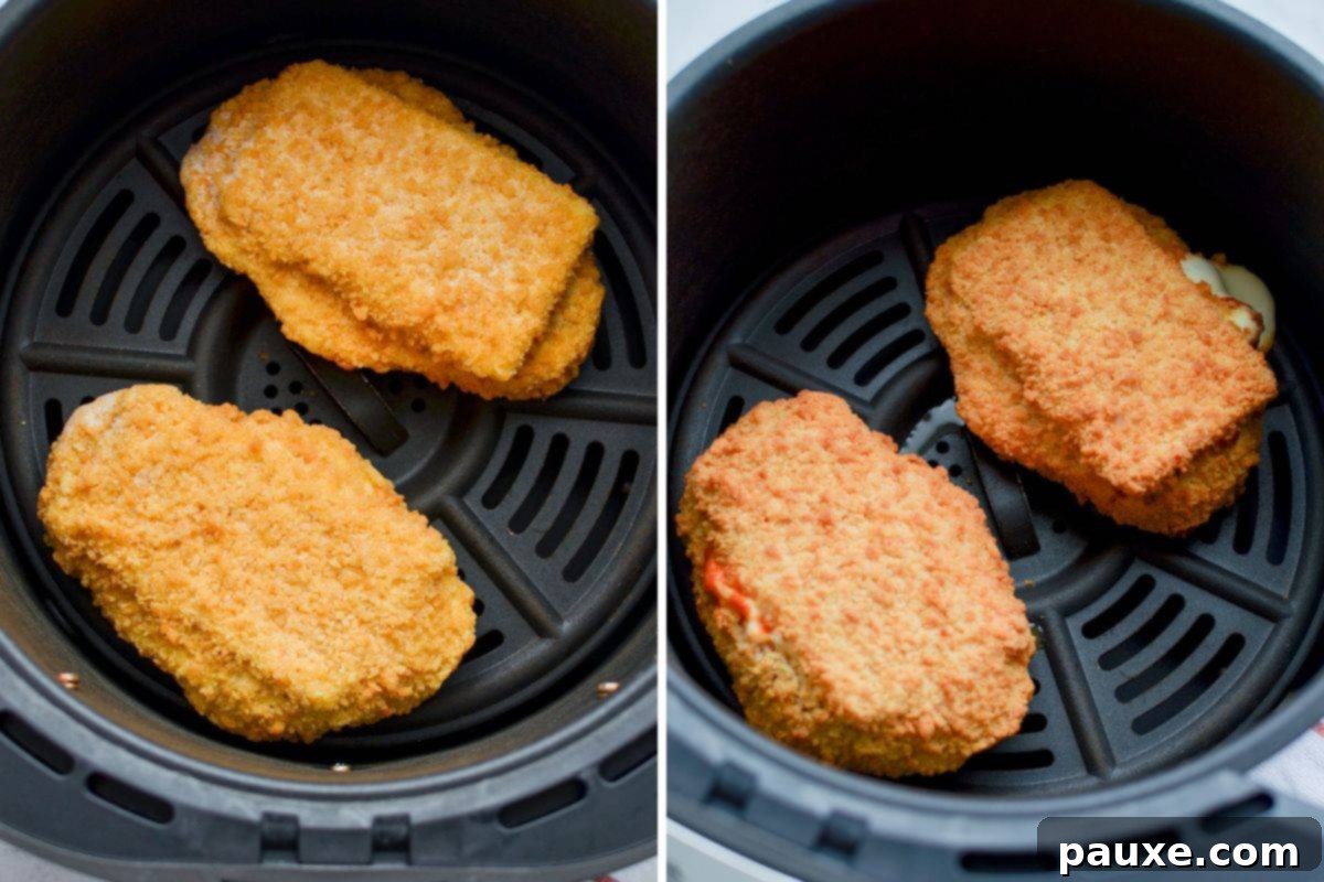 Two frozen chicken parmesan cutlets being carefully placed into the basket of an air fryer for cooking.