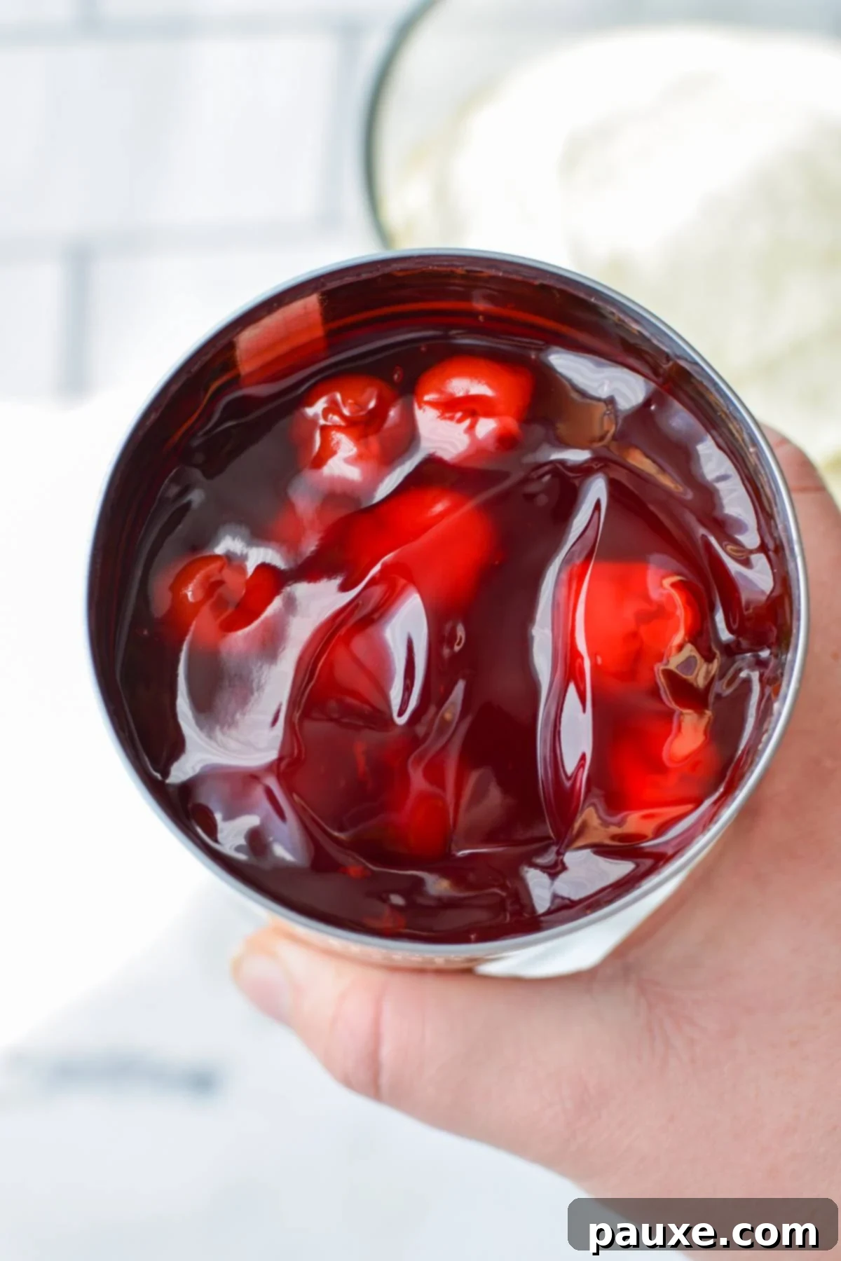 Effortless Cheesecake Delight 9 A vibrant red can of cherry pie filling, freshly opened and ready to be used as a topping for the cheesecake salad.