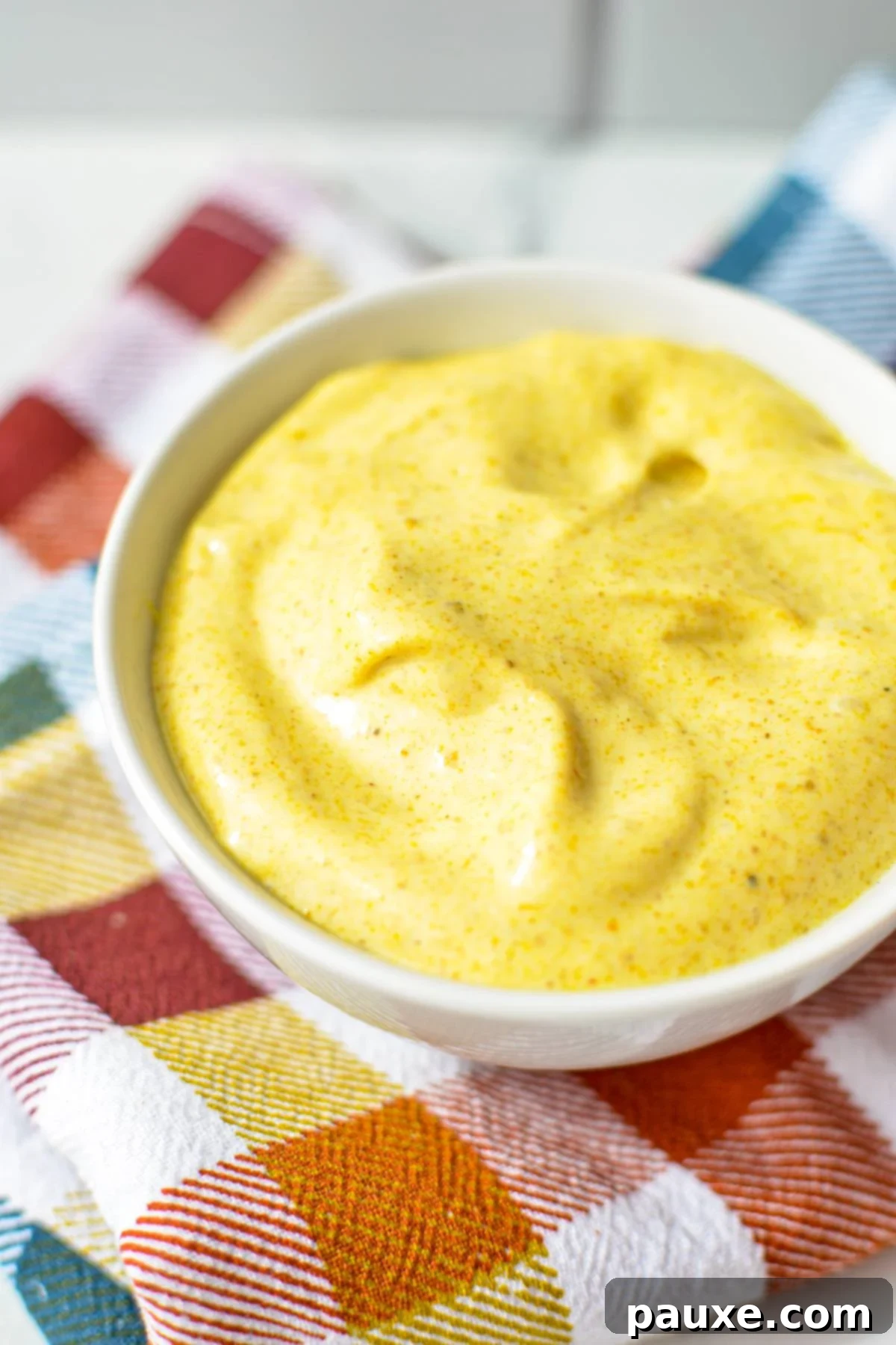 Creamy Homemade Curry Aioli 2 A small bowl of creamy, yellow curry mayonnaise, ready to be served.