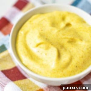 Creamy Homemade Curry Aioli 6 A small bowl of dipping sauce on a check napkin.