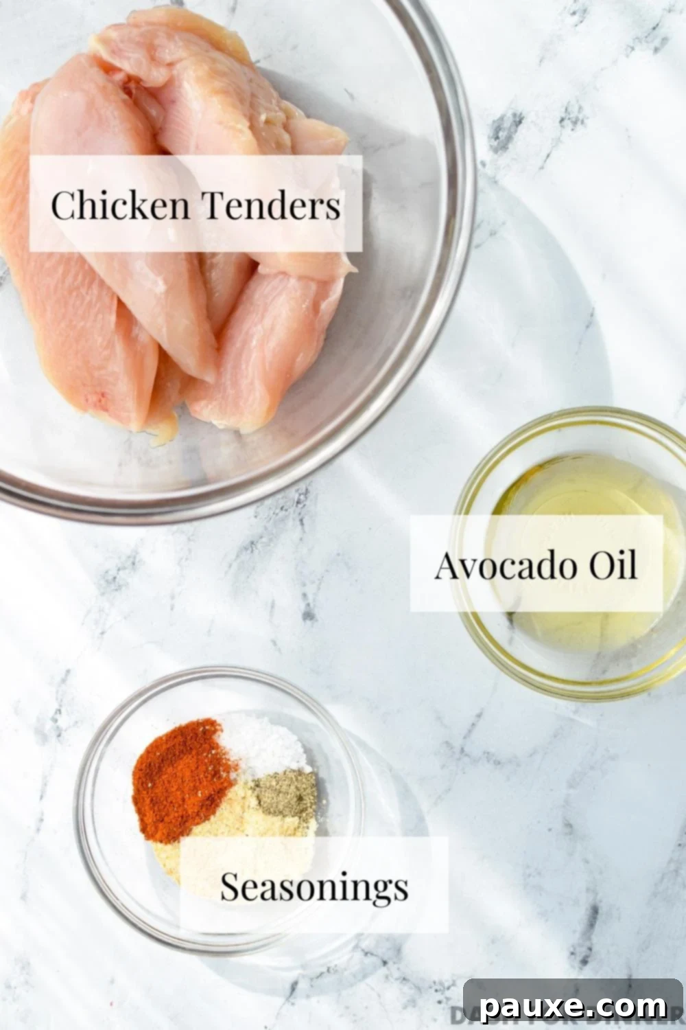 Air Fryer Naked Chicken Tenders 3 The essential ingredients laid out for air fryer chicken tenders: raw chicken tenderloins, a bottle of avocado oil, and a small bowl of mixed seasonings.