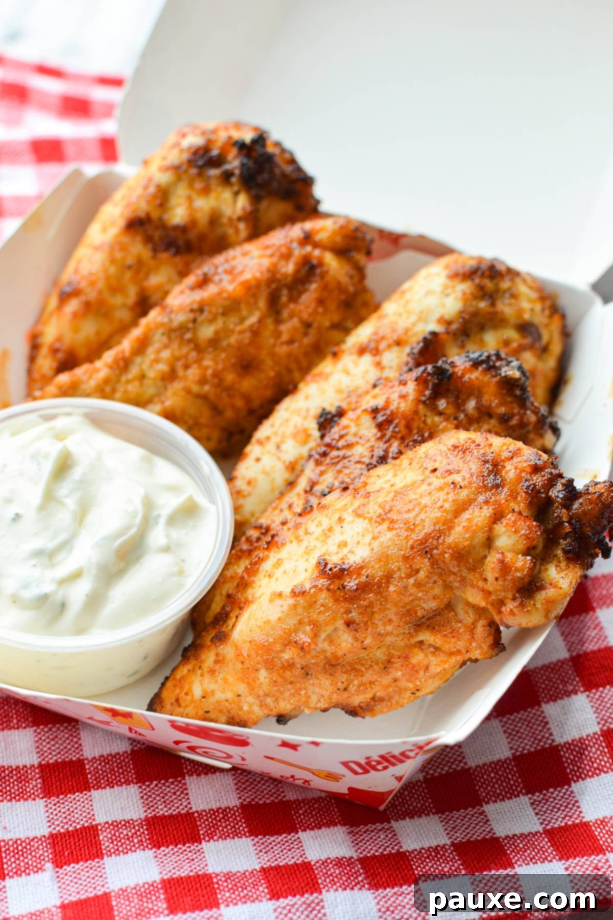 Air Fryer Naked Chicken Tenders 8 A stylish takeout box containing perfectly cooked, unbreaded air fryer chicken tenders, ready for a healthy meal.