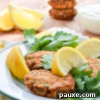 Crispy Air Fryer Salmon Cakes 12 Salmon patties on a plate, garnished with parsley and lemon.